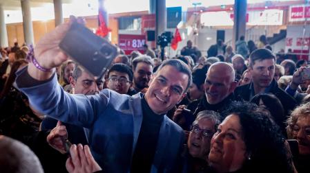 Pedro Sánchez se hace una fotografía con varias personas durante un acto que conmemora el Día Internacional de la Mujer, 8M, en el Pabellón de Convenciones de la Casa de Campo