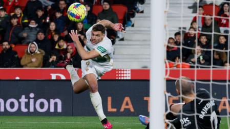 El delantero del Elche Lucas Boyé trata de superar al portero Predrag Rajkovic, del Mallorca
