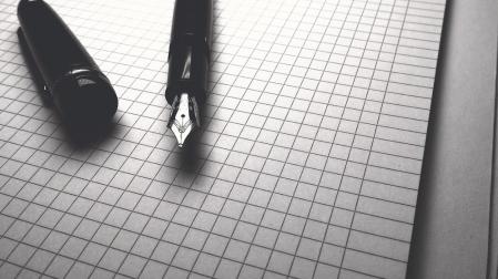 Imagen de archivo de una pluma y un papel