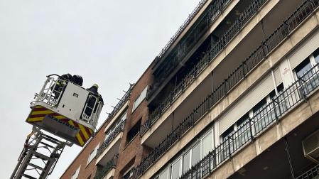 Bomberos frente a la fachada incendiada