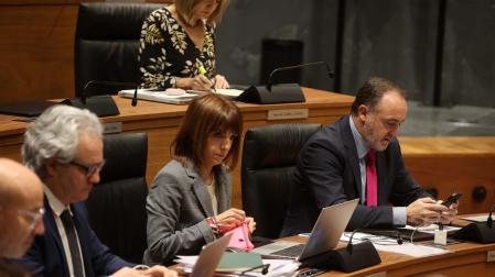 Parlamentarios de Navarra Suma consultan su teléfono móvil o su ordenador, durante un pleno de la Cámara.