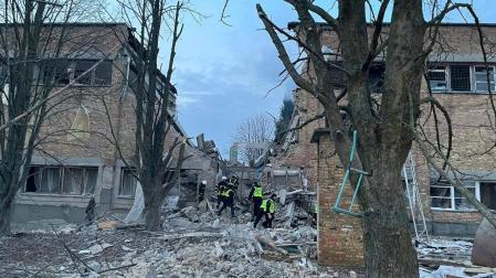 Bomberos y policías trabajan entre los escombros de un edificio tras un ataque con drones rusos, en la ciudad de Rzhyshchiv, en la región de Kiev