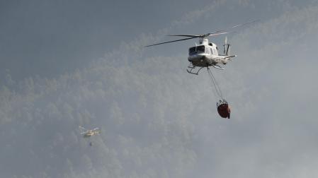 Dos helicópteros trabajan este sábado en las labores de extinción del fuego
