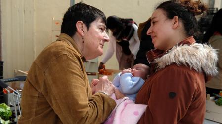 Tere González (coordinadora de Apoyo Mutuo) atiende a Asmaa y a su bebé Rima durante el reparto de alimentos del jueves. Madre e hija viven en una habitación