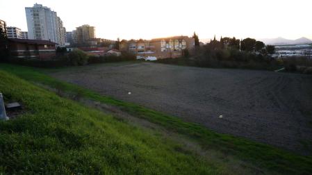 Vista de los terrenos destinados a vivienda en la nueva urbanización. Al fondo, el Pueblo Viejo