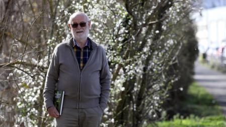Cruz Miguel Babace posa en un paraje del paseo del Arga en el polígono de Landaben en Pamplona. Sostiene el libro de orquídeas silvestres de Navarra del que es coautor