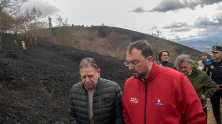 El presidente del principado de Asturias, Adrián Barbón (c), acompaña al alcalde de Oviedo, Allfredo Canteli, durante su visita a las zonas quemadas del Monte Naranco de Oviedo