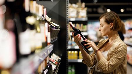 Una mujer, mirando el etiquetado de una botella