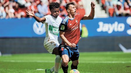Budimir cae al suelo ante la presencia de John. El árbitro señaló penalti, pero después lo anuló