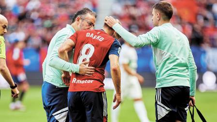 Darko Brasanac en el momento de retirarse del terreno de juego junto al doctor Andrés Valentí (izquierda) y el fisio Asier Urkia.