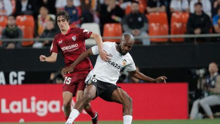 El lateral del Valencia Dimitri Foulquier (d) pelea un balón con Bryan Gil, del Valencia, durante el partido de Liga