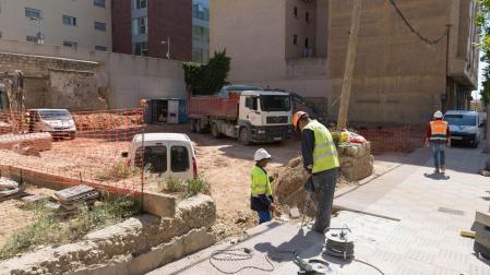 Operarios trabajan en el solar de la avenida del Barrio donde se construirán los apartamentos -al fondo, a la izda. la residencia Torre Monreal