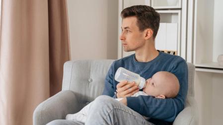 Un padre da el biberón a un bebé