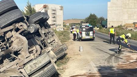 Agentes de la Guardia Civil regulan el tráfico mientras efectivos de Bomberos de Navarra realizan labores de limpieza en la carretera