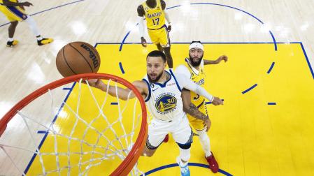 Stephen Curry entra a canasta tras sortear a Anthony Davis durante el encuentro
