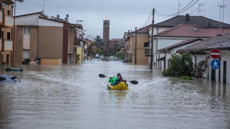 Una persona navega con un kayak inflable por una calle inundada en Cesena, tras una lluvia torrencial que azota la región de Emilia-Romaña en Italia