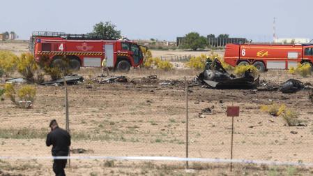 Coches de bomberos del Ejército del Aire alrededor de los restos del avión F-18 del Ejército del Aire que se ha estrellado esta mañana en la base aérea de Zaragoza