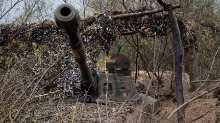 Un obús autopropulsado en una zanja cubierta por una red de camuflaje en una posición del ejército ucraniano cerca de Bakhmut
