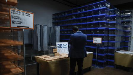 Una persona, junto a papeletas electorales para las próximas elecciones municipales del 28 de mayo