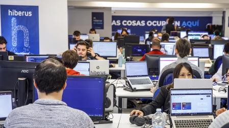Varias personas trabajan en la sede de Hiberus