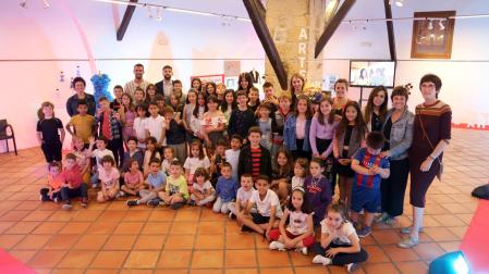 Escolares y profesorado de Lumbier posando este lunes junto a la diseñadora Edurne Ibáñez en la apertura de la exposición