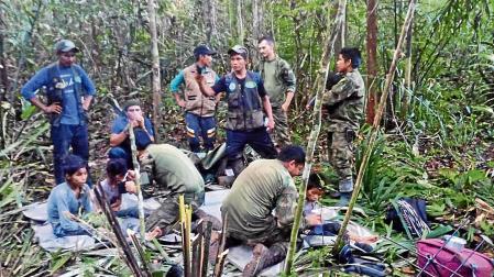Fotografía cedida por las Fuerzas Militares de Colombia que muestra a soldados e indígenas atendiendo a los niños rescatados tras 40 días en la selva, en Guaviare