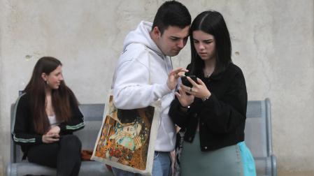 Dos alumnos que han realizado la EvAU consultan el móvil en la UPNA