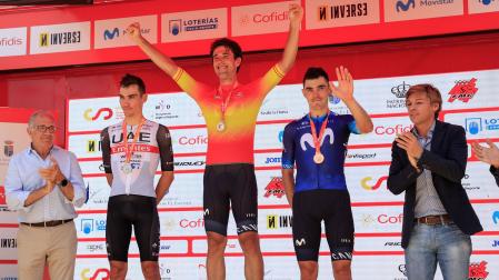 El ciclista Oier Lazkano (c), en el podio como vencedor en la prueba en línea Élite UCI-Élite masculina del Campeonato de España, junto a Juan Ayuso (i), segundo, y Alex Aramburu (d) tercero, este domingo en San Lorenzo de El Escorial