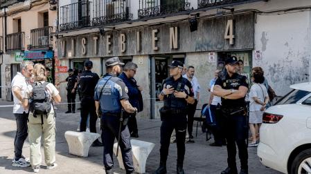 Varios agentes de Policía Nacional y Policía Local en el exterior de la tienda de ropa de trabajo 'Vistebien', donde fue apuñalad la dueña del establecimiento, en la plaza de Tirso de Molina