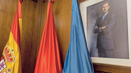 Rincón del salón de plenos de Estella, con las banderas y el retrato del rey
