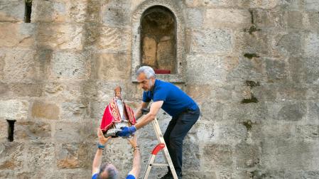 Momento en el que operarios municipales retiran la imagen de San Fermín de la hornacina de la cuesta de Santo Domingo
