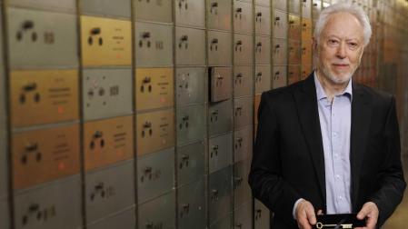 El escritor y premio Nobel J.M. Coetzee posa junto a su caja de seguridad, en el marco del depósito de su legado en la Caja de las Letras del Instituto Cervantes