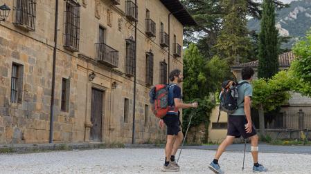 Dos peregrinos caminan esta semana frente al Monasterio de Irache cuyos baños ya están abiertos a disposición del público