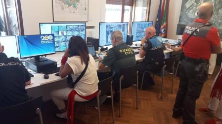 Representantes de todos los cuerpos policiales siguen las imágenes de las cámaras, ayer en el Ayuntamiento pamplonés