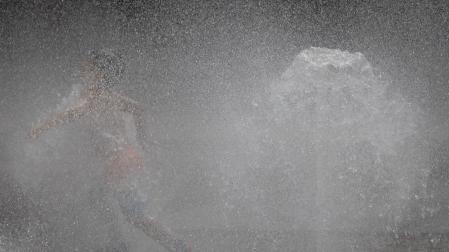 Varios niños se refrescan en una fuente en Pamplona