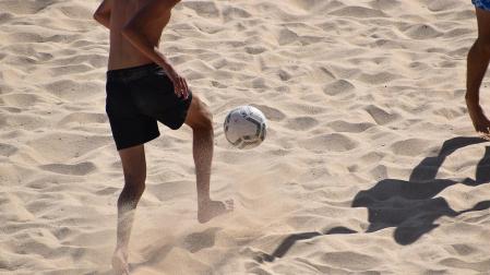 Dos personas juegan a fútbol playa