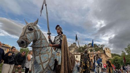 Caballeros de la corte real desfilan a caballo durante el paso del cortejo por el puente del Azucarero