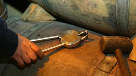 Imagen de una barrica de madera, a punto de abrirla para comprobar el estado del vino