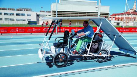 Ángel Sola, manejando el cuatriciclo, con las placas solares detrás de él
