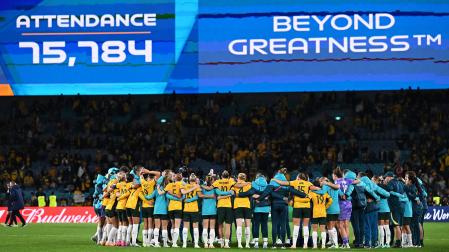 Las jugadora de Australia celebran el pase a cuartos de final tras ganar a Dinamarca. Al fondo, la cifra de asistencia del partido