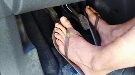 Imagen de un conductor pisando con chancletas los pedales de un vehículo