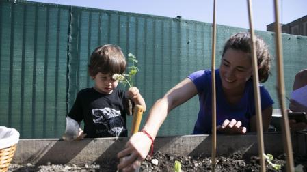 Nahia Izuriaga, educadora, planta lechugas junto a Elur, uno de los niños que ayer empezaron curso en la escuela infantil de Mendillorri