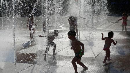 Una imagen refrescante de niños bajo unos chorros de agua en la plaza Yamaguchi
