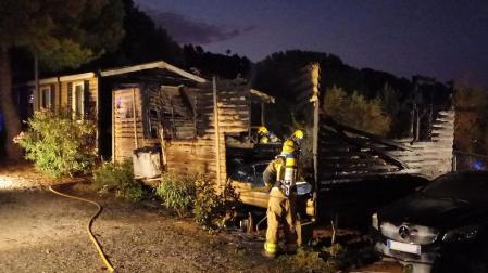Efectivos de Bomberos de Cataluña trabajan en la extinción del fuego en el bungalow afectado
