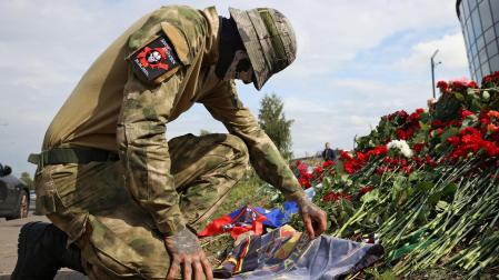 Un mercenario deja flores frente a las oficinas de Wagner en San Petersburgo en recuerdo de Prigozhin