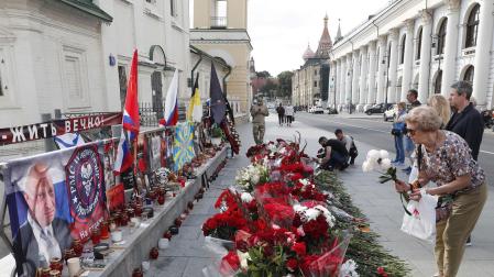 Una mujer deposita flores en un monumento informal en homenaje al jefe del Grupo Wagner, Yevgeny Prigozhin, en Moscú, Rusia