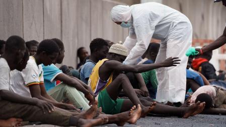 Inmigrantes en el puerto de Granadilla, al sur de Tenerife, son atendidos por personal de Cruz Roja