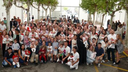Los niños que recibieron sus pañuelos rojos, junto a sus padres y otros familiares tras la entrega de esta tradicional prenda festiva que se celebró en la carpa municipal