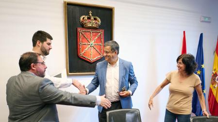 Los parlamentarios se saludan este jueves durante la constitución de una de las comisiones del Parlamento de Navarra