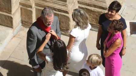 Momento en el que la reina Letizia coloca al rey Felipe VI uno de los pañuelos rojos que unos niños le habían obsequiado en la puerta del Ayuntamiento de Pamplona